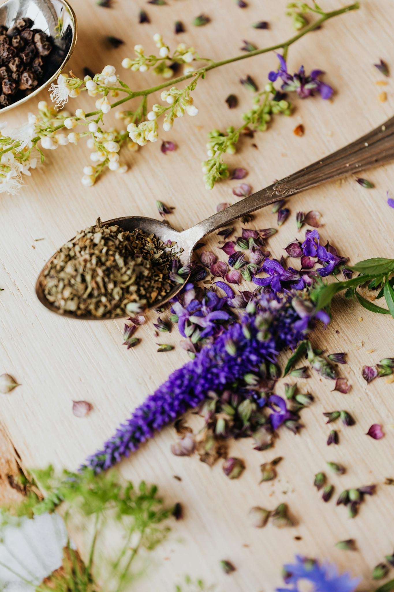 Close-up of herbal ingredients and flowers on a wooden board, showcasing natural health remedies.