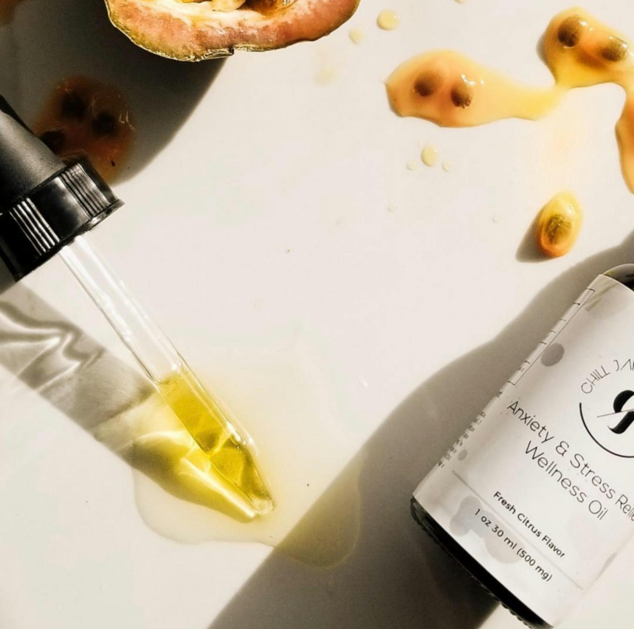 Overhead view of wellness oil dropper with spilled passionfruit seeds on surface, depicting a natural, holistic lifestyle.