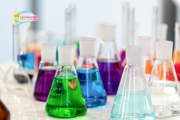 Erlenmeyerkolben mit bunten Flüssigkeiten in einem Chemielabor als Symbol für die chemische Analyse und Qualitätskontrolle ätherischer Öle.
